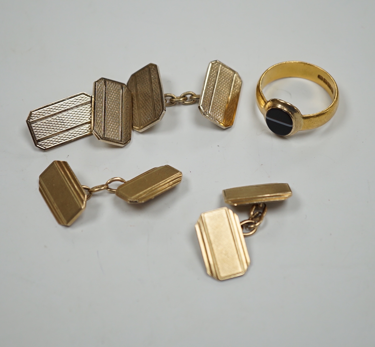 A 1930's part 22ct gold and banded black onyx set signet ring, (the ring head later associated), size Q/R, gross weight 6.8 grams, a pair of engine turned 9ct gold cufflinks, 8.5 grams and one other pair of cufflinks.